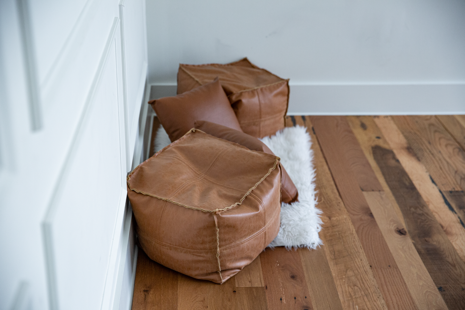 brown poufs on top of barnwood flooring